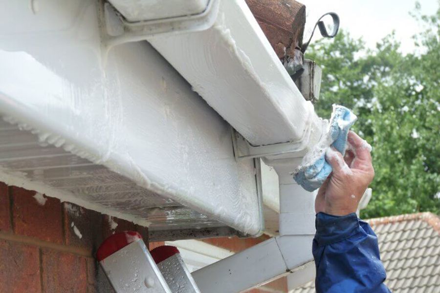 Man cleaning a roof gutter