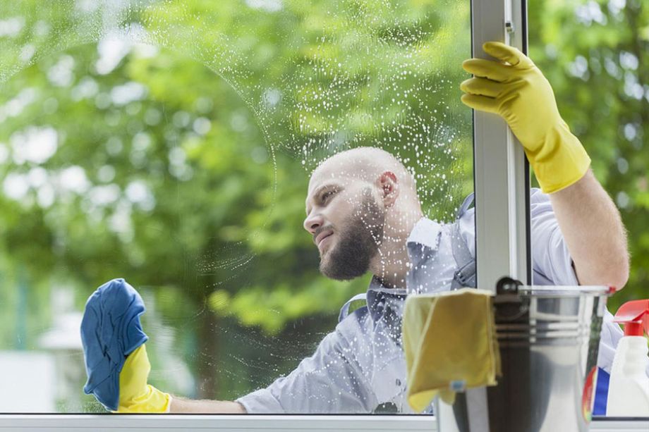 man cleaning a window with a cloth
